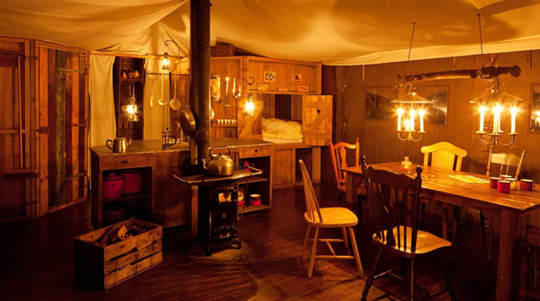 Blick in ein Luxus-Lodge-Zelt bei Kerzenschein